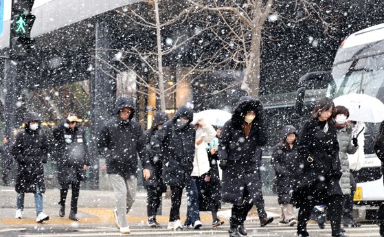 눈이 내린 17일 서울 여의도에서 점심시간 주변 직장인 등이 발걸음을 옮기고 있다. 연합뉴스