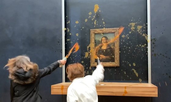 28일(현지시간) 파리 루브르박물관에서 여성 2명이 모나리자를 향해 수프를 뿌리고 있다. AFP=연합뉴스