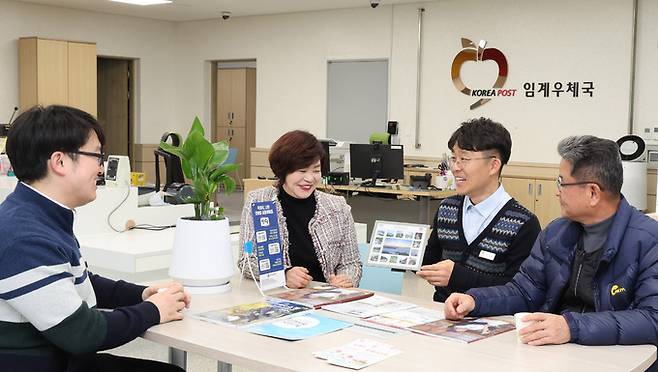 심상환 강원 정선 임계우체국장이 새롭게 단장한 우체국을 찾은 주민들과 정선을 소개하는 우표를 보며 지역의 현안에 대해 대화하며 차담을 하고 있다.