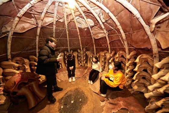 오은채·김태연 학생모델과 조유진 학생기자(오른쪽부터)가 매머드 뼈로 만든 막집에 들어가 구석기 시대 사람들의 생활 공간을 엿봤다.