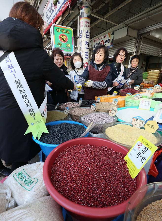 29일 부산진구청 소속 지역경제과 직원 등이 부산 부전시장에서 농수축산물에 대한 원산지표시 특별 지도점검에 나서며 상인들에게 원산지표시 안내판 등을 나눠주고 있다. 송봉근 기자