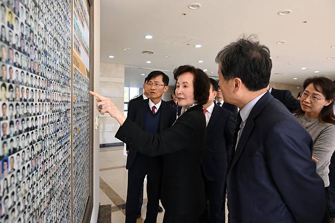 국방과학연구소(ADD) 창립 직원인 강춘강 여사(앞줄 가운데)가 2023년 11월 7일 대전 유성구 ADD를 방문해 박종승 소장(앞줄 오른쪽) 등과 함께 1970년대 함께 근무한 연구원 사진을 가리키고 있다. ADD 본부 2층에 있는 전시관 벽에는 ADD 창립 후 지금까지 근무한  3000명 넘는 모든 연구원 사진이 붙여져 있다./연합뉴스