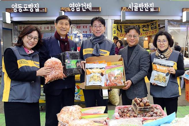 이재근 KB국민은행장(가운데)이 30일 서울 영등포구 영등포 전통시장에서 열린 '2024 설날맞이 전통시장 사랑나눔 행사'에서 김태원 영등포시장 상인회장(왼쪽 네번째), 전응림 희망친구 기아대책 부회장(왼쪽 두번째)과 기념촬영을 하고 있다. KB국민은행 제공