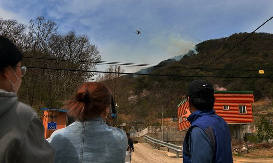 산불 발생 지역 주민들이 하늘에 떠 있는 산불진화헬기를 바라보고 있다. 프리랜서 김성태