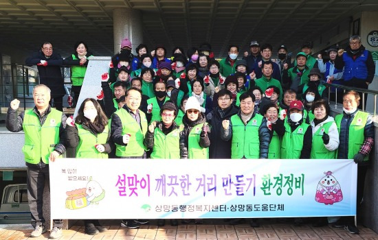 설맞이 깨끗한 거리만들기 행사에 참여한 영주 상망동 봉사단체들이 기념사진을 찍으며 파이팅을 외치고 있다(영주시 제공)