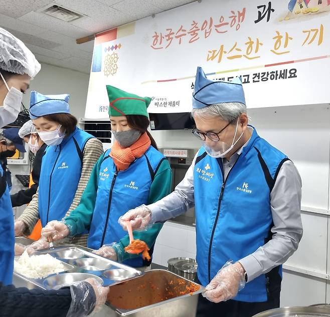 윤희성 수은 행장(사진 오른쪽)과 임직원들이 31일 서울역 노숙인 대상 무료 급식소 '따스한 채움터'에서 배식 봉사를 하고 있다.(수출입은행 제공)