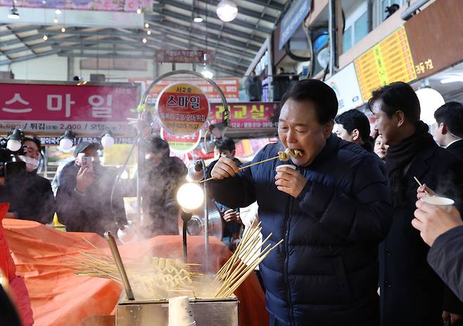 윤석열 대통령이 1월25일 경기도 의정부시 의정부제일시장을 찾아 어묵을 먹고 있다. ⓒ연합뉴스