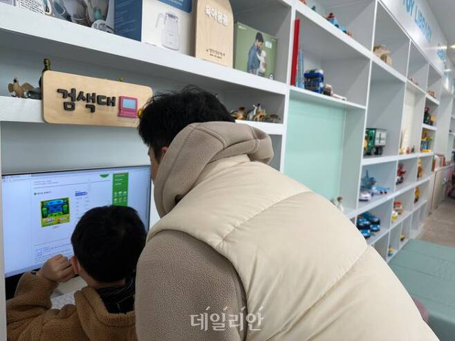 서울장난감도서관에서 부모가 자녀와 함께 검색대에서 장난감을 검색하고 있다.ⓒ데일리안 김하나 기자