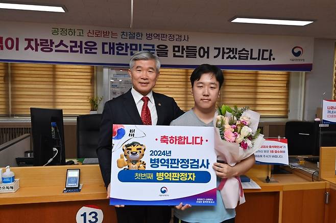 이기식 청장이 현장에서 이지환씨에게 꽃다발을 주며 검사결과를 축하했습니다. / 사진공동취재단