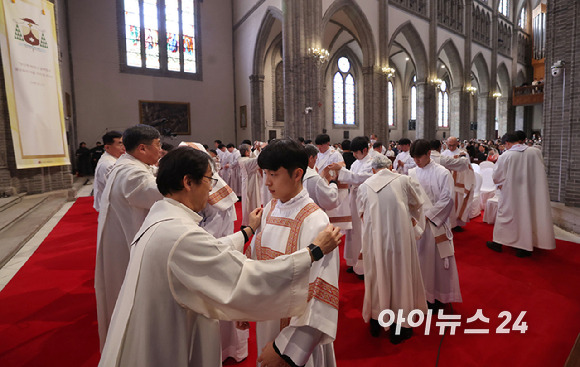 2024년 천주교 서울대교구 부제 서품식이 열린 1일 서울 중구 명동대성당에서 추천 사제들이 부제 수품자들에게 달마티카(부제복)를 입혀주고 있다. [사진= 사진공동취재단]