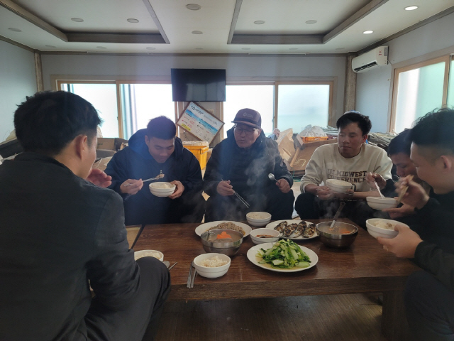 ▲ 양양 수산리 숙소에 모여 앉은 김승선 선장이 베트남 출신 선원들과 베트남 음식으로 저녁식사를 하는 모습. 