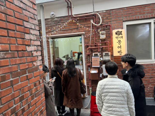 성수 현대붕어빵 가게 앞에 로봇을 보려는 사람들이 모여 있다. (사진=지디넷코리아 신영빈 기자)