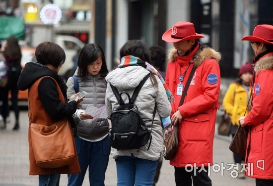 한국을 찾은 중국 관광객이 명동에서 관광안내를 받는 모습.