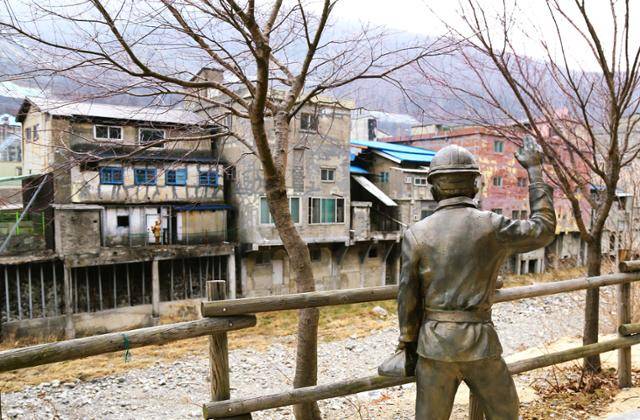 까치발 건물 뒤편에 탄광으로 출근하는 남편과 배웅하는 부인 조각상이 설치돼 있다.