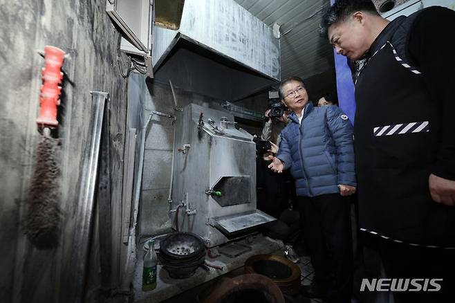 [서울=뉴시스] 홍효식 기자 = 이정식 고용노동부 장관이 지난달 29일 오전 중소영세기업 중대재해처벌법 적용 관련 사업장 순회로 서울 중구 명동의 한 음식점을 방문해 숯가마를 살펴보고 있다. (공동취재) 2024.01.29. photo@newsis.com