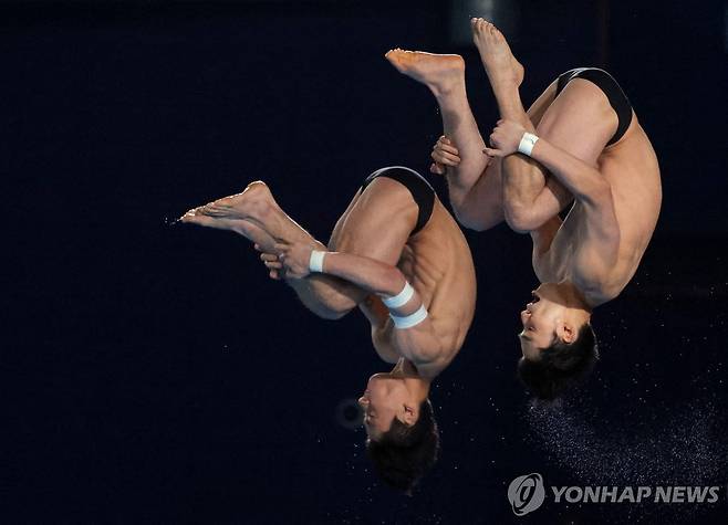 김영택-신정휘의 싱크로 연기 (도하 로이터=연합뉴스) 김영택(왼쪽)과 신정휘가 9일(한국시간) 카타르 도하 하마드 아쿠아틱센터에서 열린 2024 세계수영선수권 다이빙 남자 싱크로 10m 플랫폼에서 턱 동작으로 연기를 펼치고 있다.