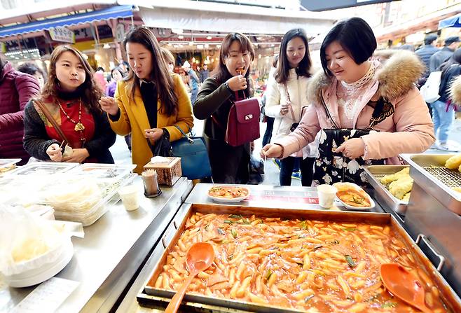 인천 남동구 모래내시장에서 관광객들이 떡볶이를 먹고 있다. 인천관광공사 제공