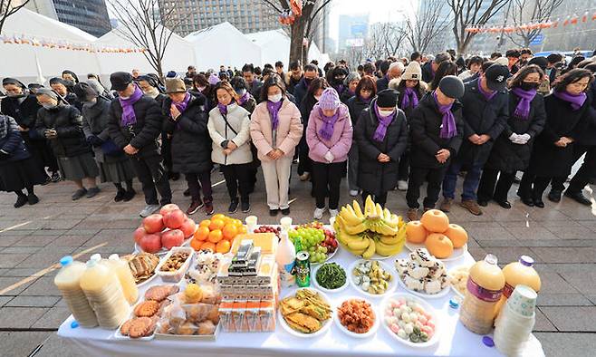 설날인 10일 서울광장에 마련된 10·29 이태원 참사 희생자 합동분향소에서 유가족들이 떡국 나눔을 하기 전 묵념하고 있다. 연합뉴스