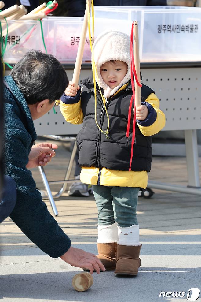 지난 11일 광주 북구 역사민속박물관을 찾은 한 아이가 팽이를 돌리려 채를 두손에 들고 있다. 2024.2.12/뉴스1 ⓒ News1 김태성 기자