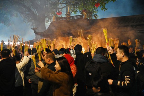 10일 중국 광시성 난닝시의 한 사찰을 찾은 참배자들이 향을 피우며 새해 행운을 기원하는 모습. AFP=연합뉴스