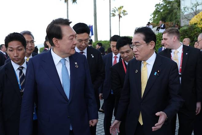 G7 의장국인 일본 초청에 따른 참관국(옵서버) 자격으로 G7 정상회의 참석한 윤석열 대통령이 지난해 5월 20일 일본 히로시마 그랜드 프린스 호텔에서 열린 G7 정상회의에서 각국 정상들과 기념촬영을 마친 뒤 기시다 후미오 일본 총리와 대화하고 있다. [공동취재] 연합뉴스