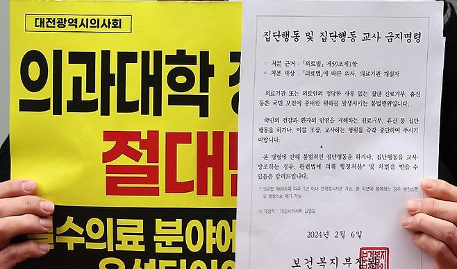 대전시의사회가 15일 오후 대전시 중구 대흥동 국민의힘 대전시당 앞에서 정부의 의대 증원 방침에 반대하는 집회를 하고 있다. 이날 한 참가자가 보건복지부가 지난 6일 보낸 집단행동 금지명령 안내문을 들고 있다. ⓒ연합뉴스