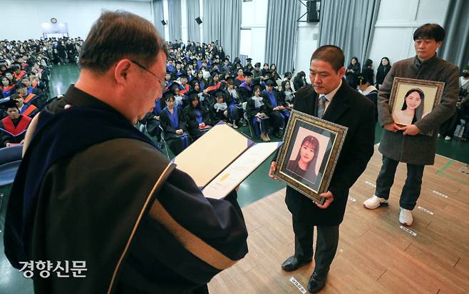 명예 학사학위 수여 이태원 참사 희생자 유연주씨 아버지 유형우씨(가운데)와 진세은씨 아버지 진정호씨가 서울 구로구 성공회대학교에서 열린 학위수여식에서 고인을 대신해 명예 학사 학위를 받고 있다. 성동훈 기자