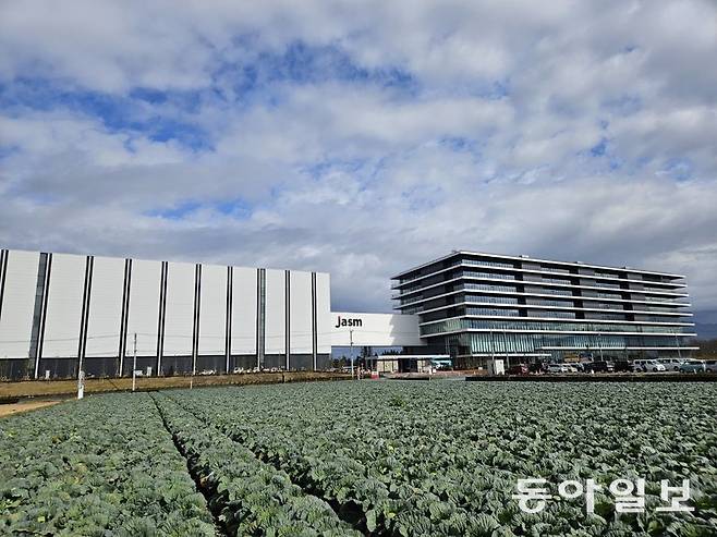 15일 일본 구마모토현 기쿠요정에 들어선 대만 반도체 기업 TSMC 공장 전경. 양배추밭 옆에 지어진 공장 외벽에 일본 현지법인명 ‘Jasm’이 적힌 간판이 걸렸다. 이곳에는 소니, 도쿄일렉트론 등 일본 유수의 반도체 관련 기업들이 몰려 있다. 구마모토=이상훈 특파원 sanghun@donga.com