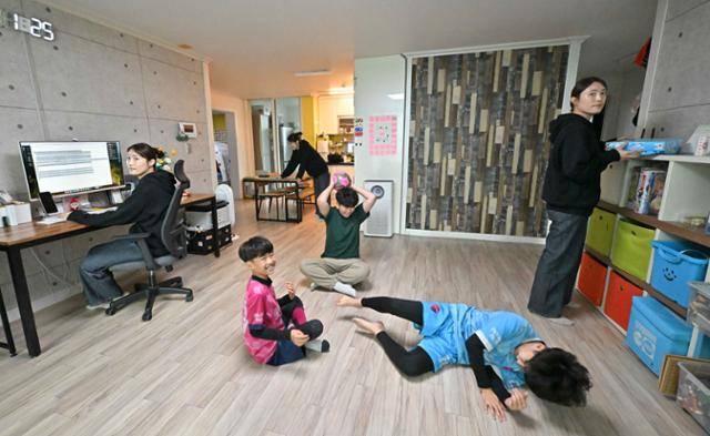 주부 데이터 라벨러 이유리씨(검정 상의) 가족이 1월 3일 전북 전주시 자택에서 일상의 모습을 보여주고 있다. 집안일과 데이터 라벨링 작업을 하는 이씨, 공놀이를 하는 삼 형제의 사진을 여러 장 찍은 다음 겹쳐 합성했다. 전주=정다빈 기자