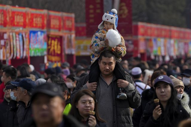중국 베이징 룽탄공원에서 지난 11일(현지시간) 한 남성이 아이에게 목말을 태우고 이동하고 있다. AP연합뉴스