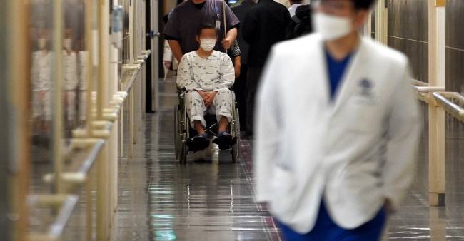 환자는 뒷전 전공의 사직 등 의사단체의 집단행동으로 환자 피해 우려가 커지고 있는 가운데 19일 오전 서울 소재 한 대학병원에서 환자들 사이로 의료진이 이동하고 있다.  박윤슬 기자