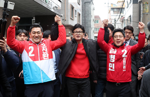 국민의힘 한동훈 비대위원장(가운데)이 20일 오후 서울 광진구 화양동을 찾아 광진을에 단수 공천을 받은 오신환 전 의원(왼쪽)과 광진갑 김병민 전 최고위원의 손을 들어올려 주민들에게 인사하고 있다. 뉴시스