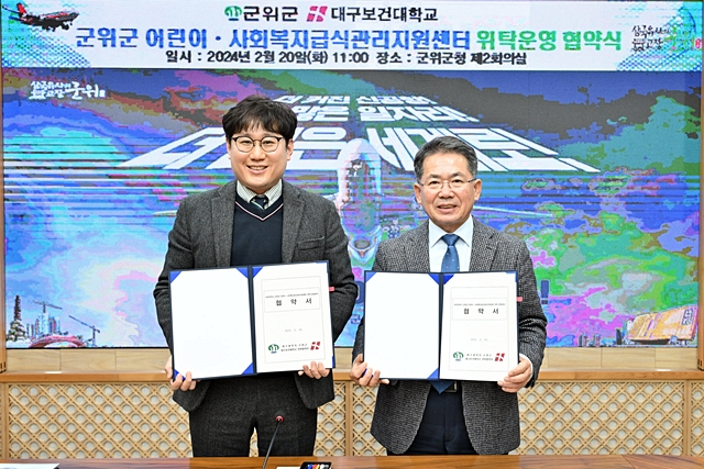 김진열 군위군수(오른쪽)가 이전형 대구보건대 산학협력단장(왼쪽)과 20일 군청 제2회의실에서 어린이·사회복지급식관리지원센터 운영을 위한 민간위탁 업무협약을 체결한 뒤 협약서를 들어보이고 있다./사진제공=대구 군위군