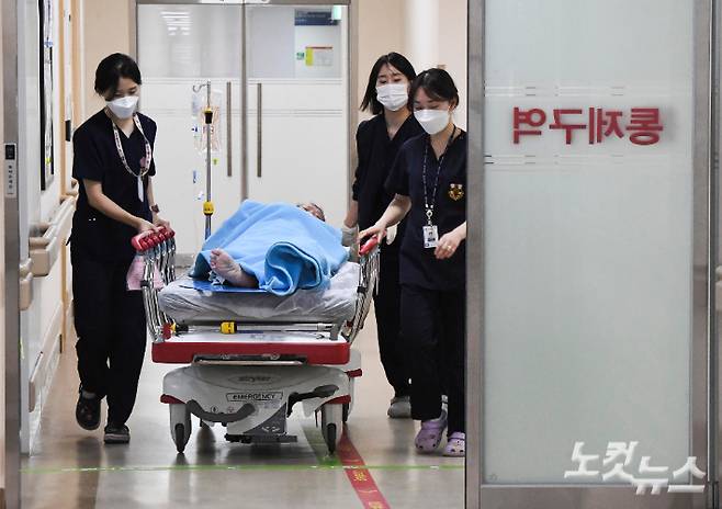 전공의들의 집단 사직으로 의료대란이 가시화하며 정부가 군병원 12곳 응급실을 민간인에게 개방한 20일 오후 의료진이 경기도 성남시 국군수도병원 응급실에서 민간인 환자를 옮기고 있다. 성남=사진공동취재단