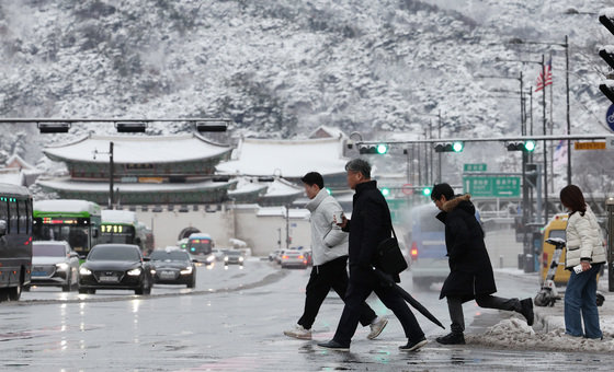 22일 서울 종로구 광화문네거리에서 시민들이 눈 쌓인 도로를 조심스레 걸으며 일터로 향하고 있다. 2024.2.22/뉴스1