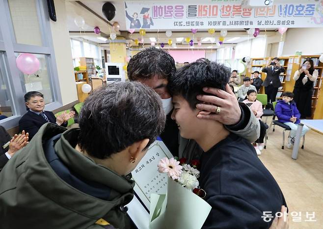 21일 오전 경상남도 밀양시 태룡초에서 열린 제96회 졸업장 수여식에서 졸업생 김준호 군(13)이 부모님에게 최고의 부모님 상을 전달한 뒤 포옹하고 있다. 밀양=이한결 기자 always@donga.com