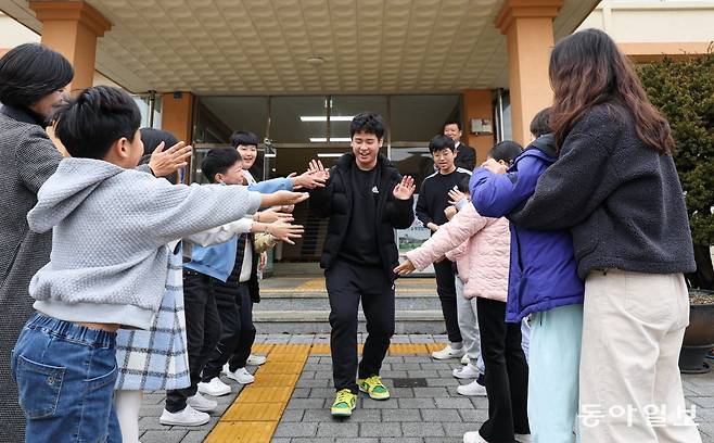 21일 오전 경상남도 밀양시 태룡초에서 열린 제96회 졸업장 수여식이 끝난 뒤 졸업생 김준호 군(13)이 재학생들과 하이 파이브를 하며 나서고 있다. 밀양=이한결 기자 always@donga.com