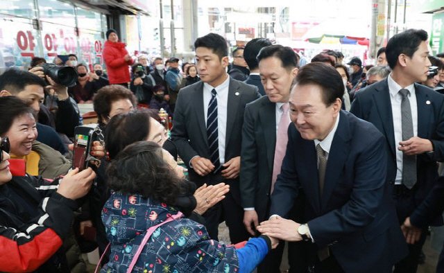 ▲ 윤석열 대통령이 22일 낮 경남 마산어시장을 찾아 상인 및 시민들과 악수하고 있다. 사진/대통령실 공동취재단