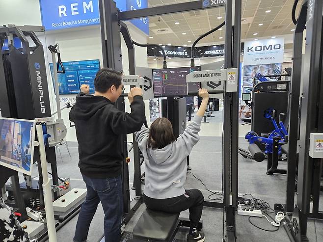 한 참가자가 로봇공학 기술을 기반으로 운동을 코칭해 주는 기구를 체험하고 있다.
