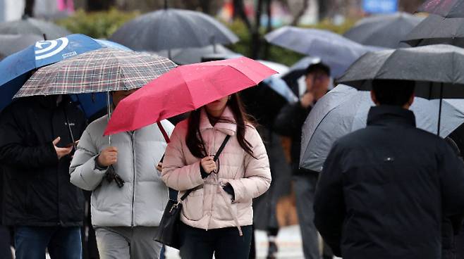 22일 낮 12시쯤 수도권과 충청권에 비가 그칠 것으로 보인다. 이 밖의 강원 내륙과 경상권은 오후, 전라권은 밤까지 비나 눈이 내릴 전망이다. 사진은 지난 21일 서울 광화문네거리 인근에서 시민들이 우산을 쓰고 걸어가는 모습. /사진=뉴스1