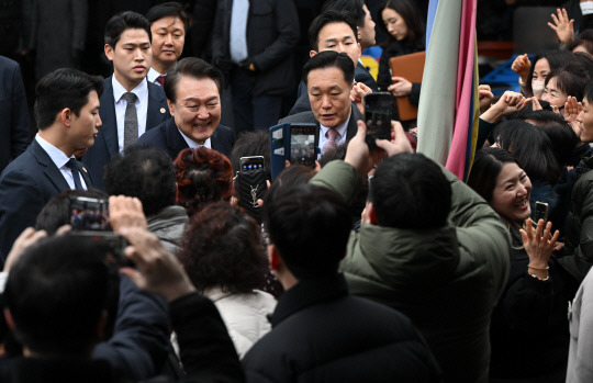 윤석열 대통령이 22일 경남 창원시 마산합포구 마산어시장을 찾아 시민들과 인사하고 있다.  연합뉴스