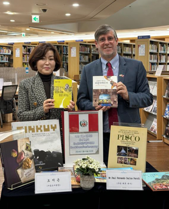 오지은(왼쪽) 서울도서관 관장이 주한 페루대사관 도서기증식에 참석해 책을 들고 있다.서울시청 제공