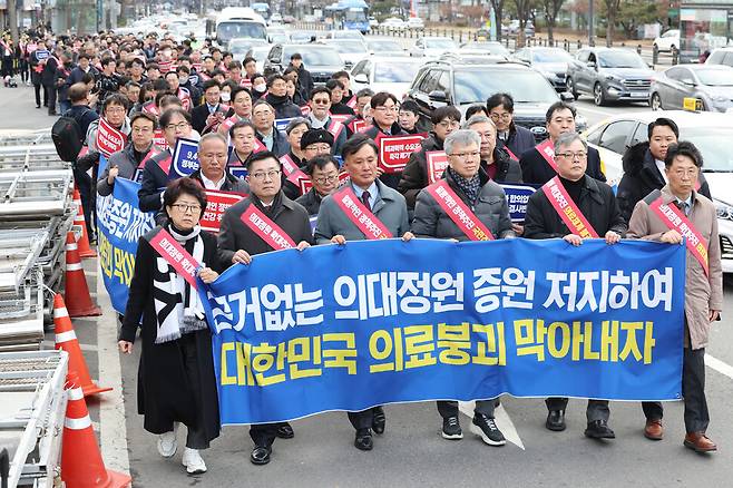 25일 오후 서울 용산구 대한의사협회에서 열린 ‘전국 의사 대표자 확대회의 및 행진 행사\'에서 참가자들이 대통령실 방향으로 행진하며 의대 정원 증원 반대 구호를 외치고 있다. 연합뉴스