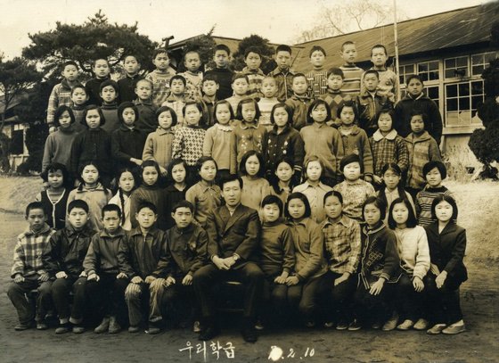 광시초 46회 졸업생인 김기원(63)씨가 보여준 1974년 2월 10일 당시 졸업식 사진. ‘우리 학급’이라는 글씨와 함께 같은 반 57명의 학생들이 교사와 함께 찍혔다. 김기원씨 제공