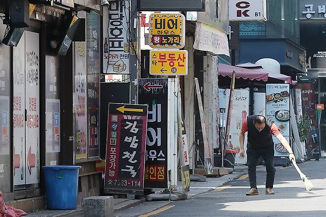 서울 종로구 먹자골목에서 한 업주가 가게 앞을 청소하고 있다. (ⓒ뉴스1, 무단 전재-재배포 금지)