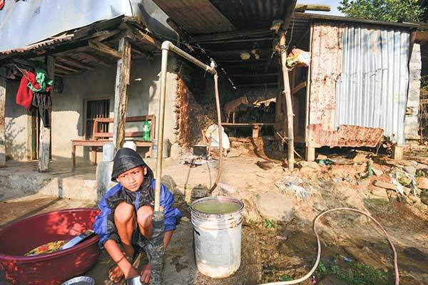 설거지를 하는 아이. 히말라야 시골 마을의 전형적인 삶의 모습이다.