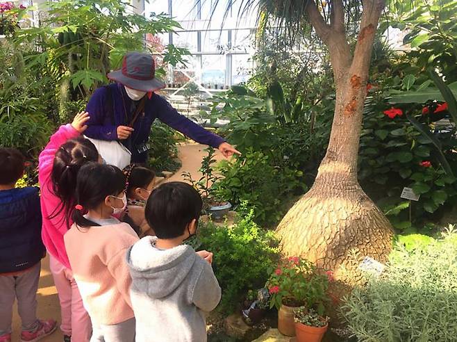 성남시 식물원 내 온실에서 열대식물에 대해 설명을 듣고 있는 어린이들 ⓒ성남시 제공
