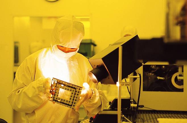 삼성전자 반도체공장에서 작업자가 웨이퍼 원판 위 회로를 만드는 데 쓰이는 기판인 포토마스크를 점검하고 있는 모습./삼성전자 제공