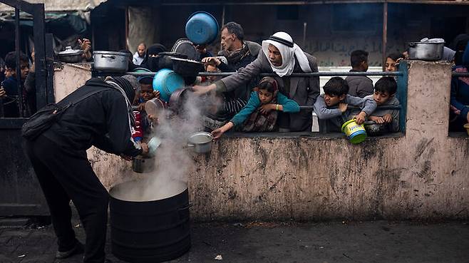 무료 식사를 위해 줄을 선 가자지구의 팔레스타인인들