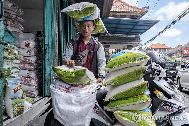 지난 26일 인도네시아 발리주 덴파사르에서 한 남성이 쌀자루를 나르고 있다.  [EPA 연합뉴스 자료사진. 재판매 및 DB 금지]